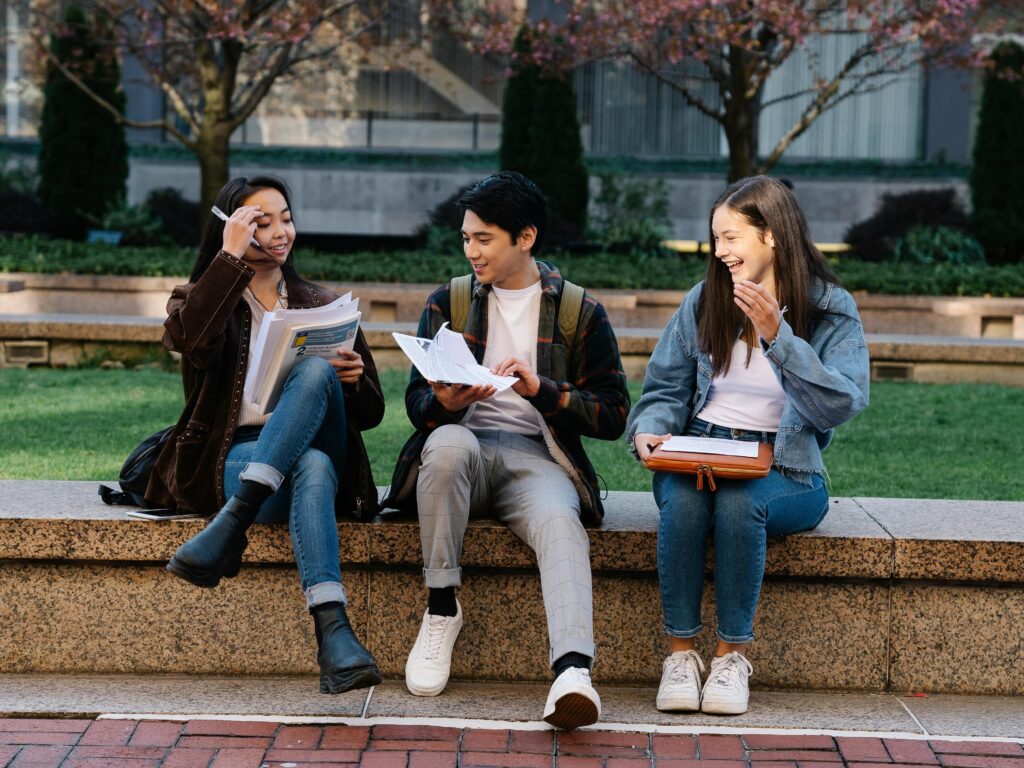 Students laughing and studying outside the university